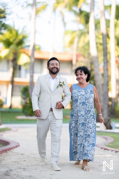 A joyful moment between a groom and his mother during a beachside wedding ceremony in a tropical resort, celebrating love and family in a beautiful setting