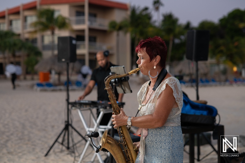 Jazz performance at sunset on the beach with a saxophonist and electronic musician creating a vibrant atmosphere in a tropical location