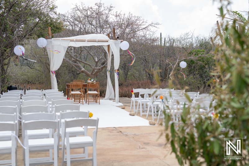 Wedding ceremony setup at Fort Beekenburg in Curacao featuring chairs arranged for guests and a decorative arch for the bride and groom
