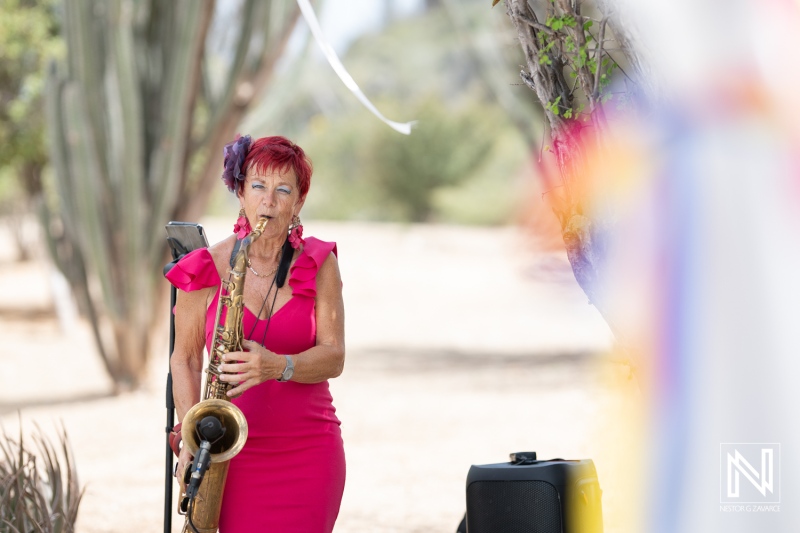 Saxophonist performs at a vibrant wedding ceremony at Fort Beekenburg in Curacao during a sunny afternoon celebration