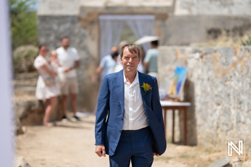 Groom arrives at his wedding ceremony at Fort Beekenburg in Curacao, surrounded by beautiful scenery and loved ones celebrating the special day