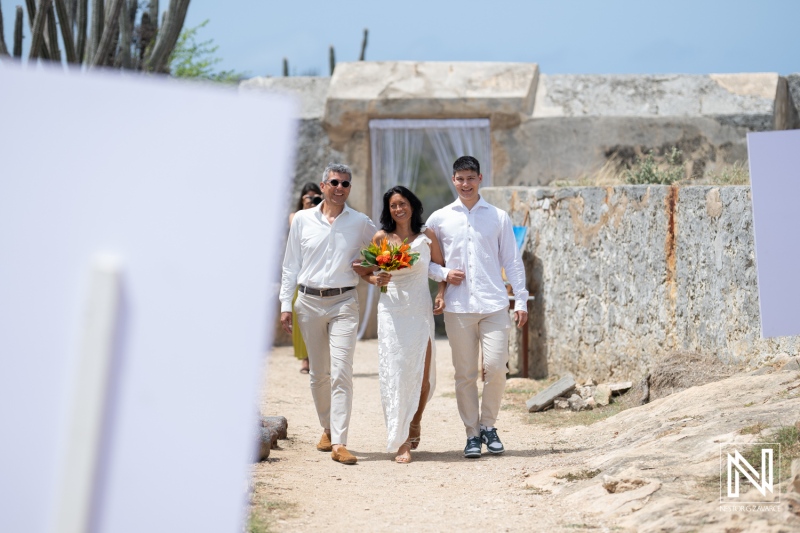 Couple exchanges vows at a beautiful wedding ceremony at Fort Beekenburg in Curacao, celebrating love against a historic backdrop on a sunny day