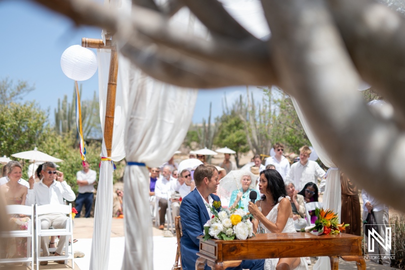 Ceremony held at Fort Beekenburg in Curacao, featuring a joyful couple exchanging vows surrounded by family and friends under the bright Caribbean sun