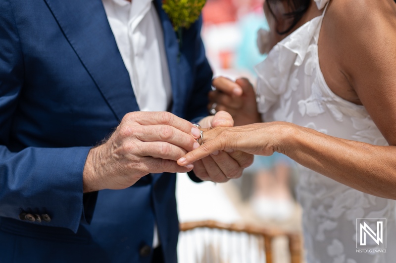 Couple exchanges wedding vows and rings at Fort Beekenburg in Curacao during a beautiful outdoor ceremony surrounded by loved ones