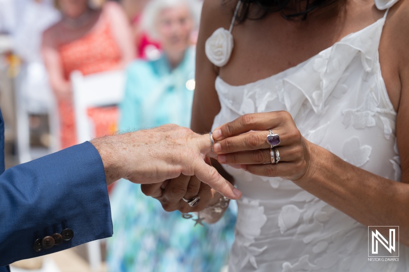 Couple exchanges wedding rings during a beautiful ceremony at Fort Beekenburg in Curacao under bright sunshine
