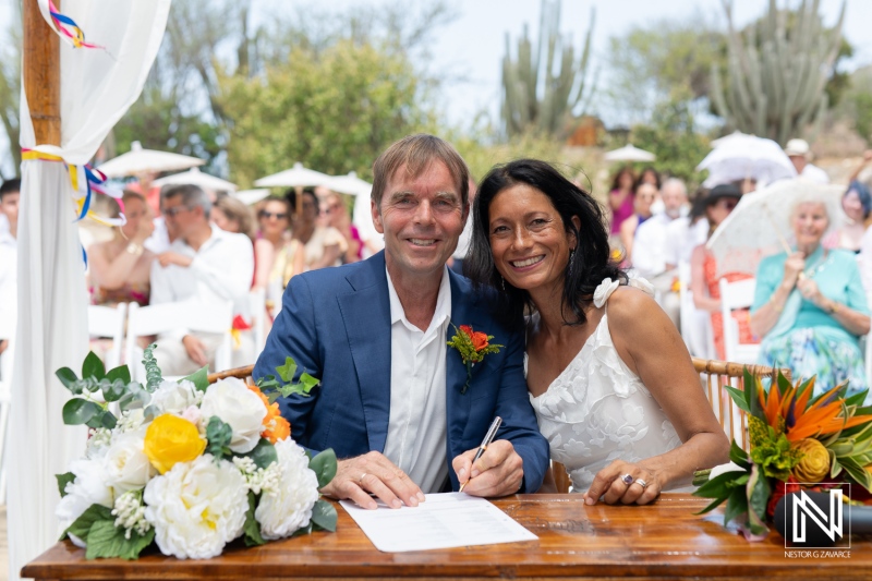 Wedding ceremony at Fort Beekenburg in Curacao featuring a joyful couple signing their marriage certificate under a sunny sky