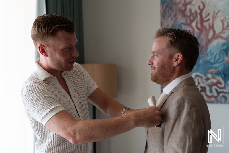 Groom gets ready with assistance from best man in a charming Curacao wedding location