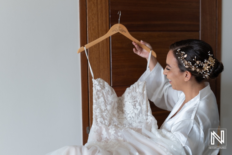 Curacao wedding preparation highlighting a joyful bride admiring her elegant wedding dress in a beautiful setting