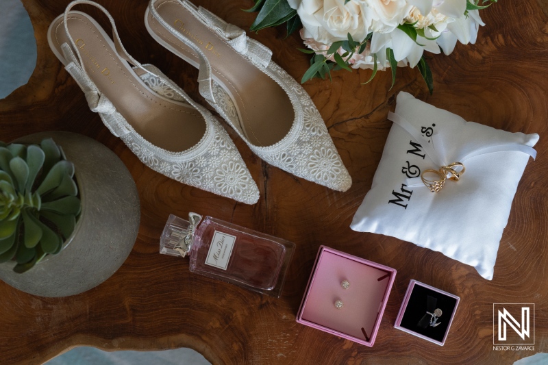 Wedding preparations in Curacao featuring elegant bridal accessories and a stunning floral arrangement on a rustic wooden table