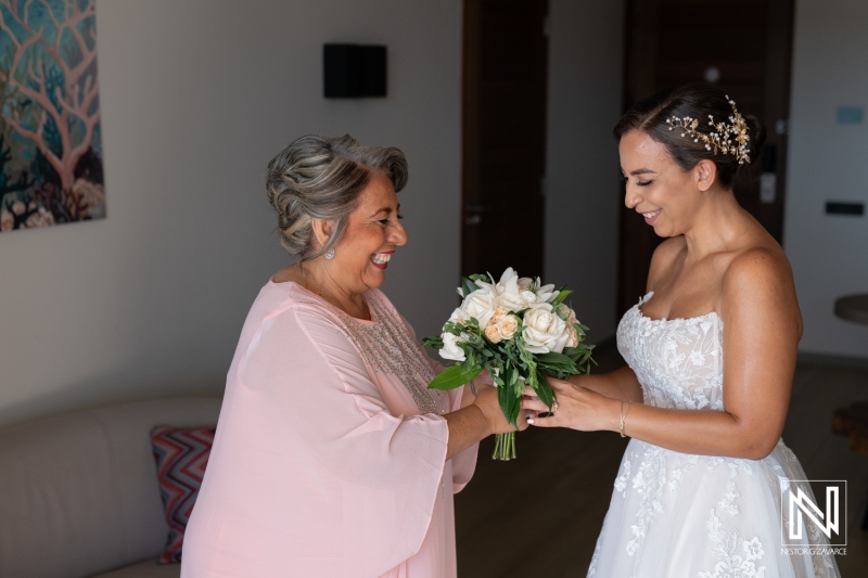 Bridal moment in Curacao with joyful bride and mother exchanging flowers before wedding ceremony on a beautiful day