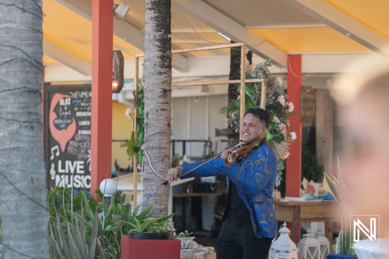 Wedding celebration in Curacao features live music performed by a talented violinist in a vibrant outdoor venue