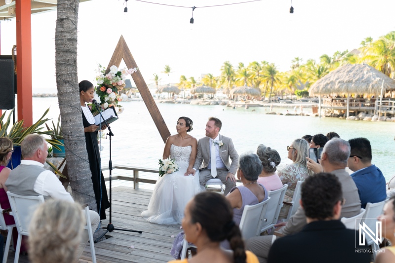 Couple exchanging vows during a beautiful wedding ceremony in Curacao by the sea with guests celebrating the special occasion