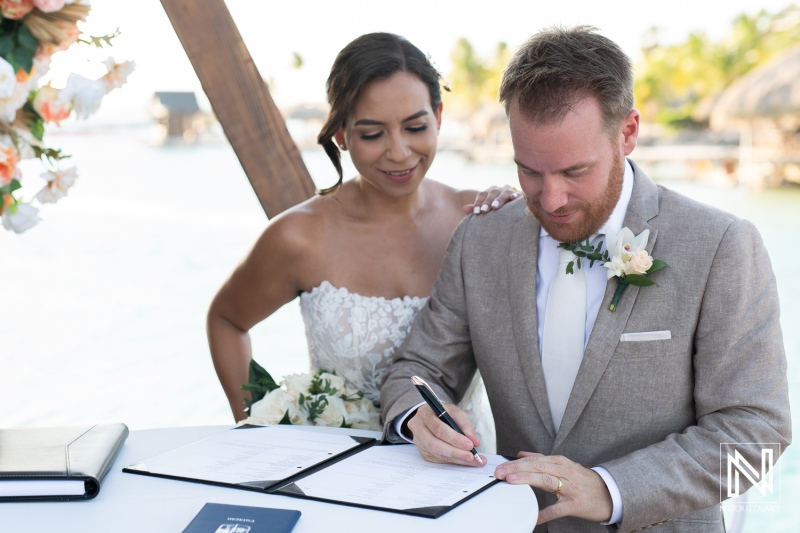 Couple signs wedding documents at a beautiful beachfront venue in Curacao during a romantic ceremony