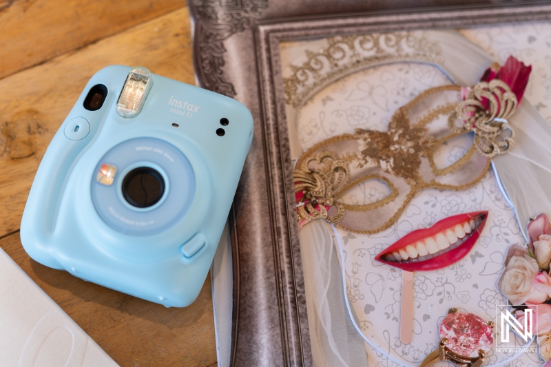 Capture of wedding memories in Curacao with a vintage camera alongside a decorative masquerade invitation