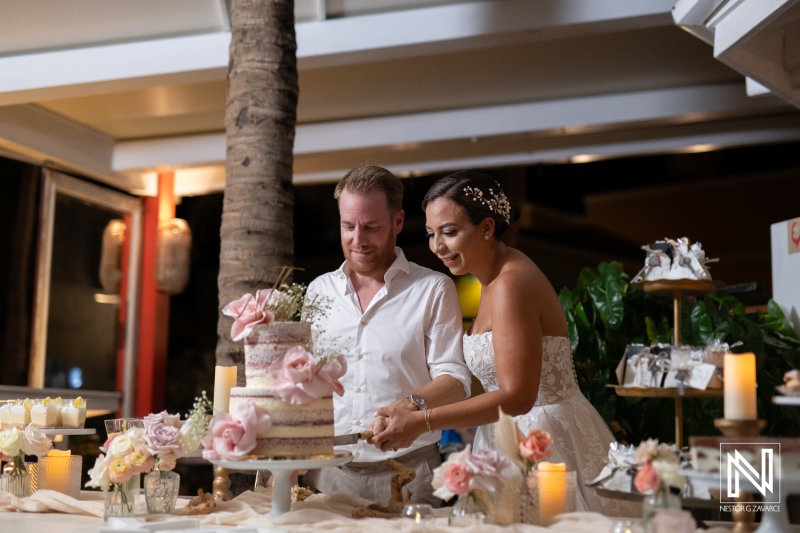 Couple celebrates their wedding reception with a beautifully decorated cake in Curacao during a romantic evening